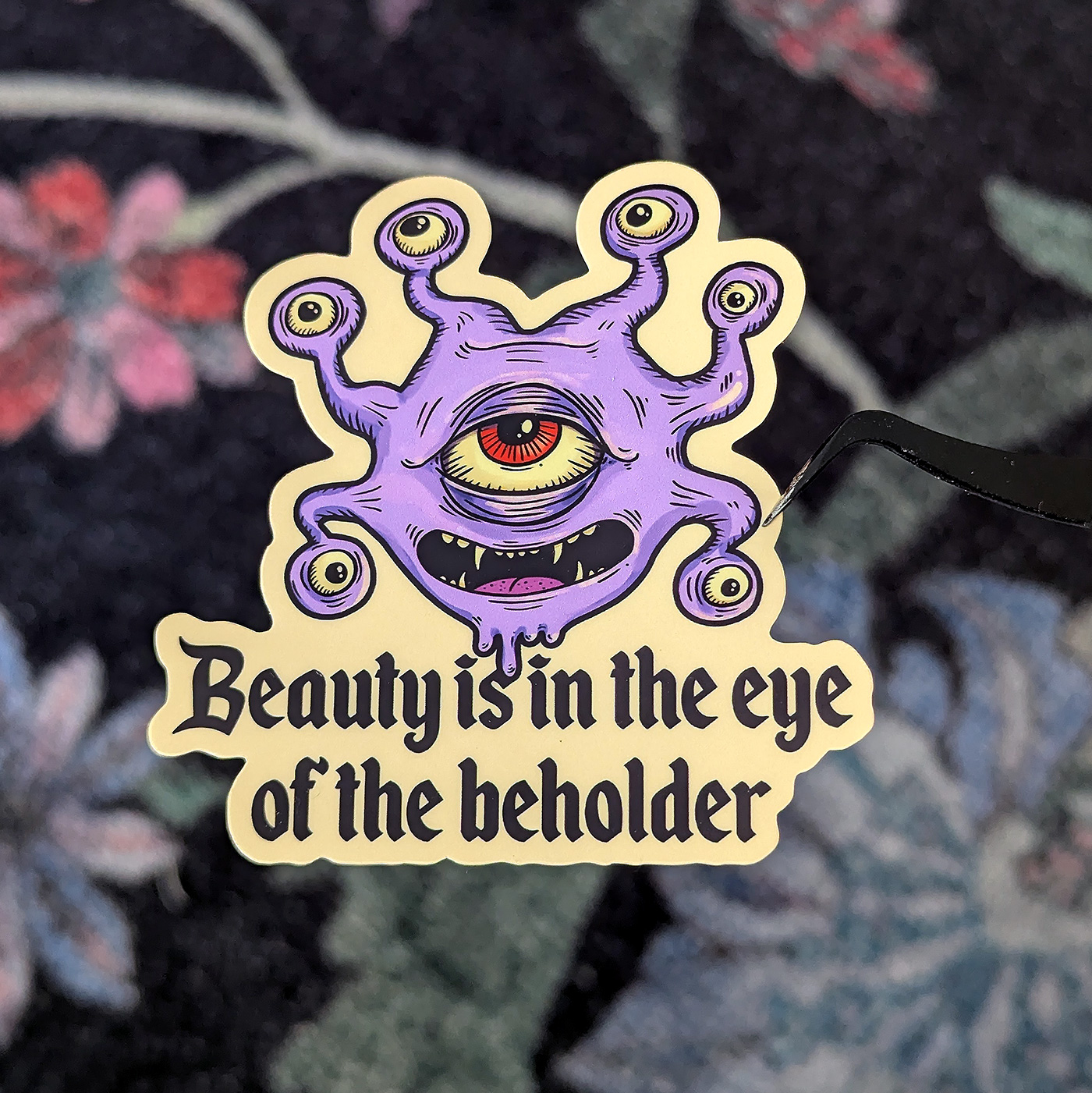 Klistermärke med en Beholder och texten Beauty is in the eyes of the Beholder.