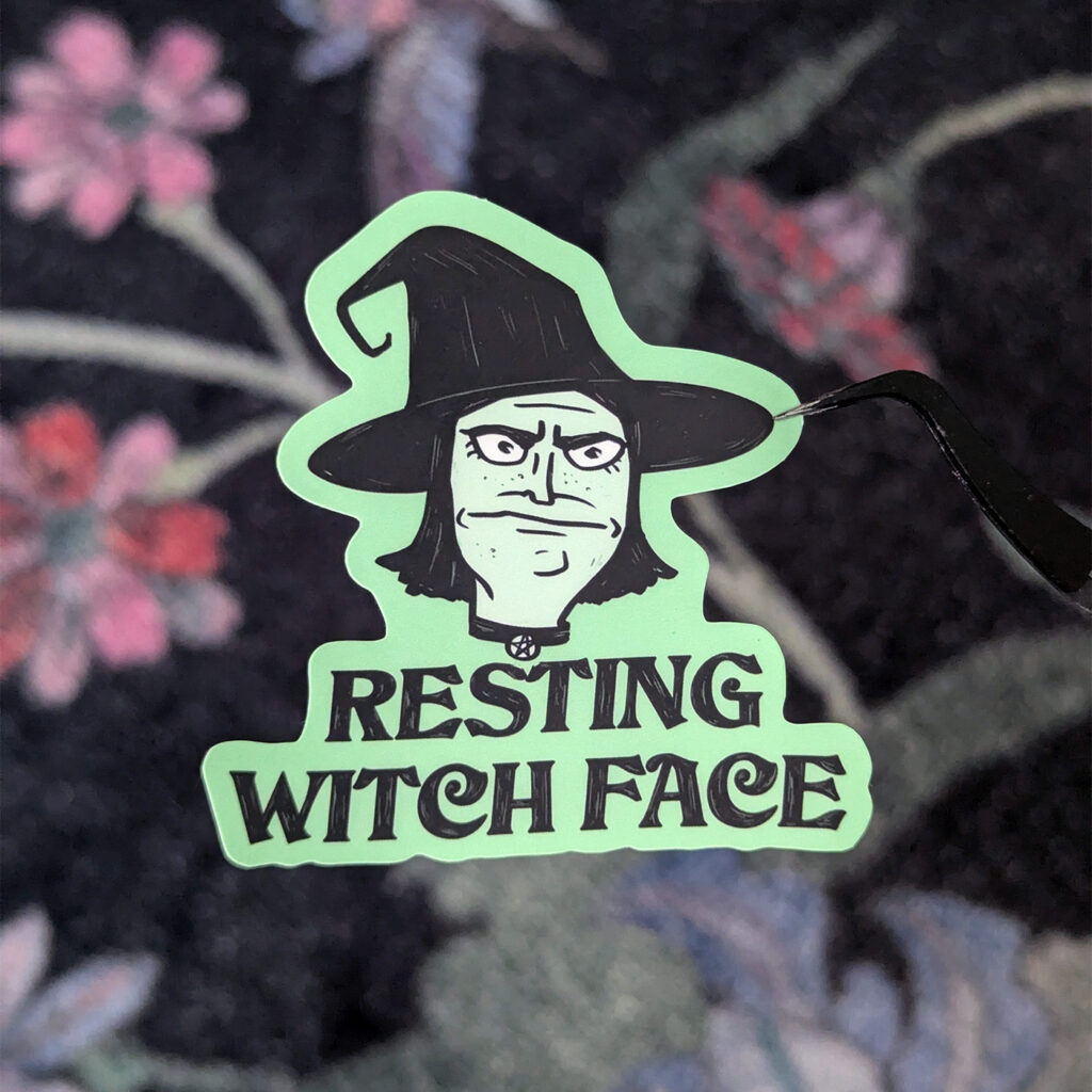 Klistermärke i grönt och svart, med en häxa och texten Resting Witch Face